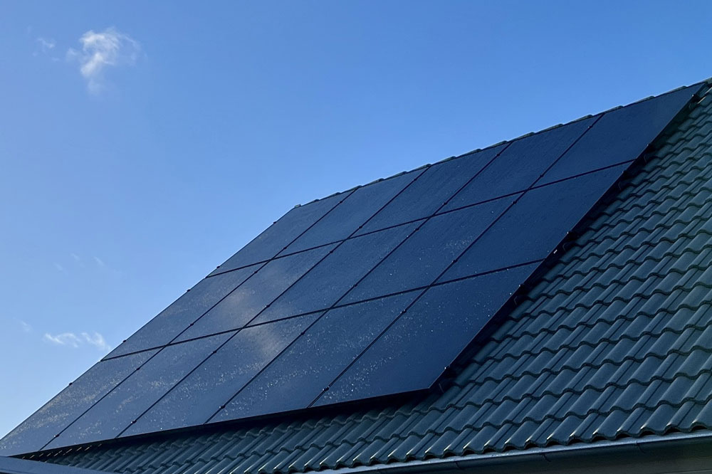 Solceller på en villa med blå himmel i bakgrunden